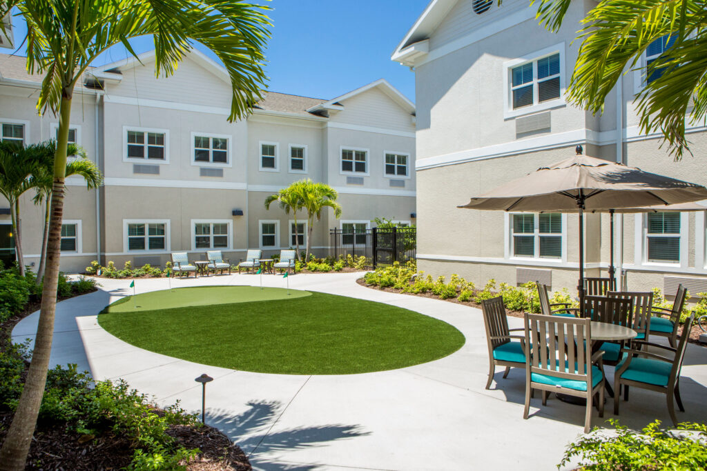 A putting green is the centerpiece of the landscaped courtyard at Heritage Oaks of Englewood, a senior living community near Venice, FL.