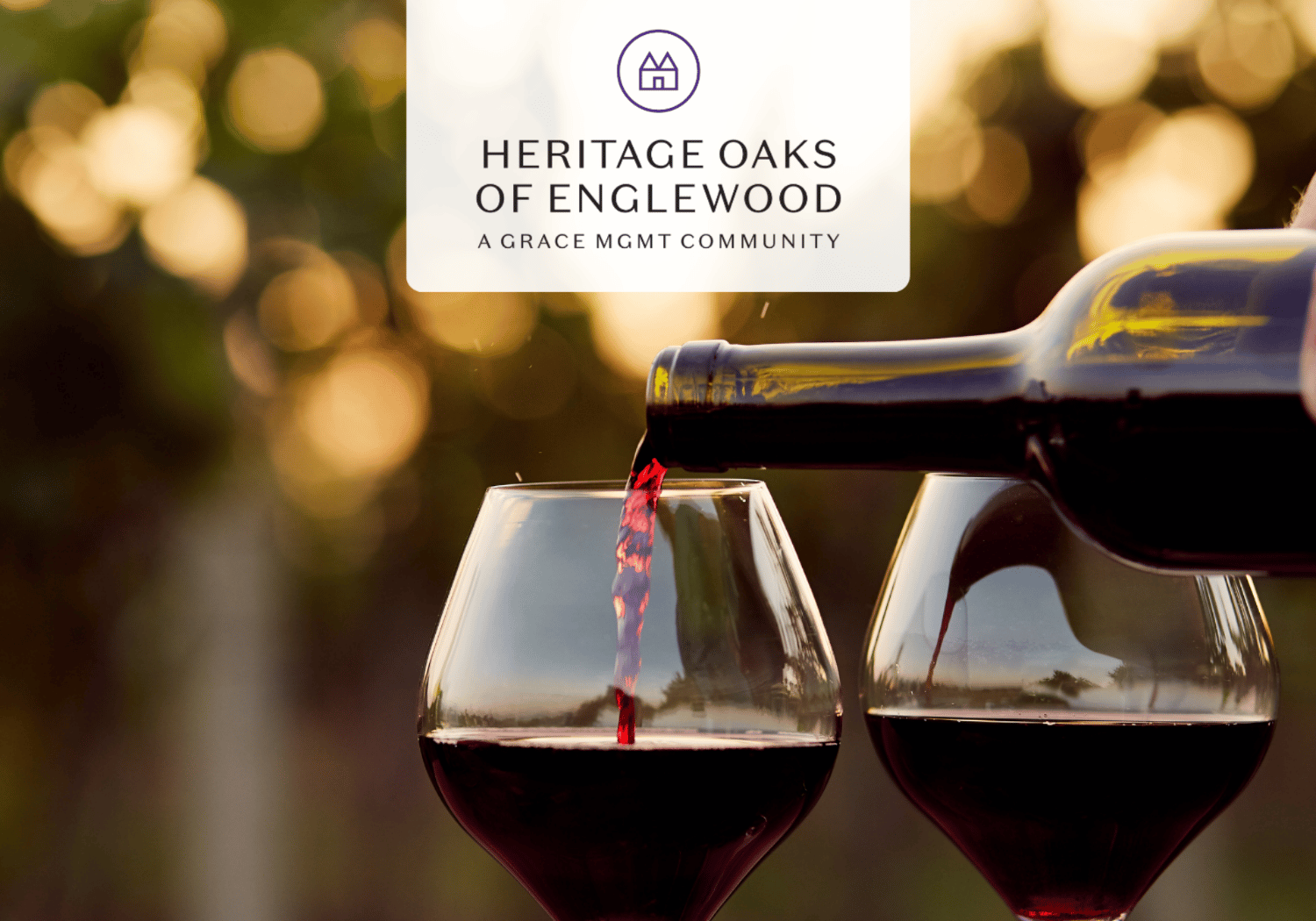 Two wine glasses being filled with red wine from a bottle, with the Heritage Oaks of Englewood logo above.