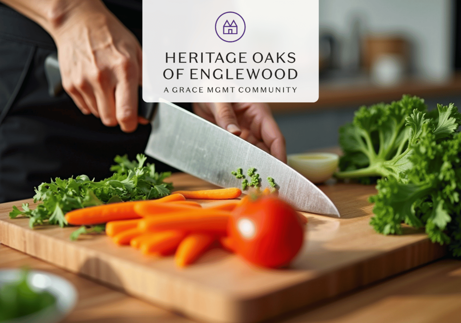 Person chopping carrots on a wooden cutting board with leafy greens and a tomato nearby; logo overlay reads 'Heritage Oaks of Englewood' at top.